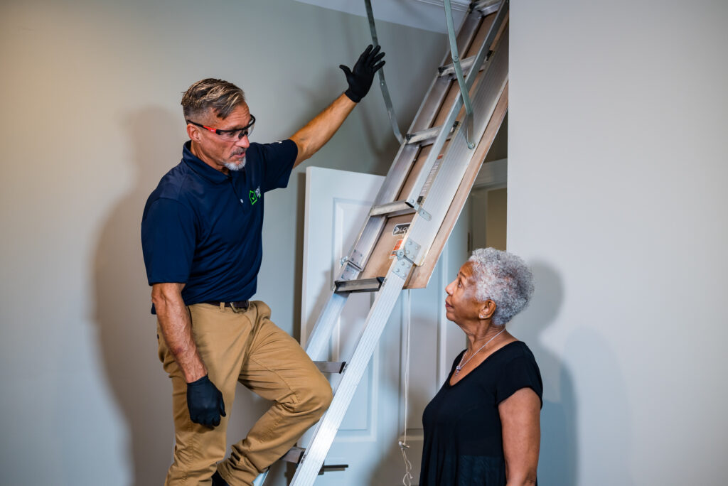Pest Control maintenance looking in the attic for homeowner